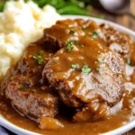 Slow-cooked cube steak with rich brown gravy served over mashed potatoes
