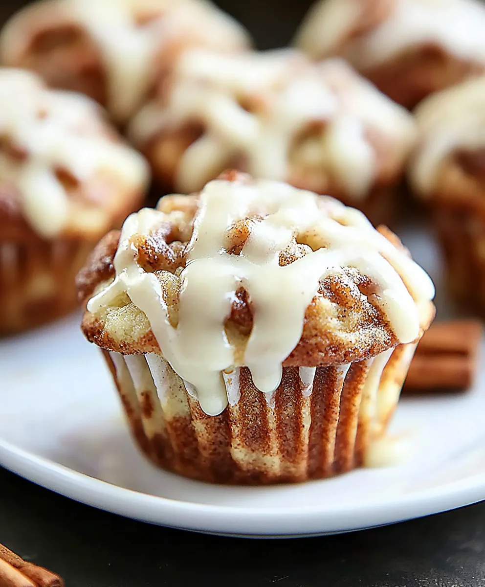 Cinnamon Roll Muffin drizzled with vanilla glaze on a white plate