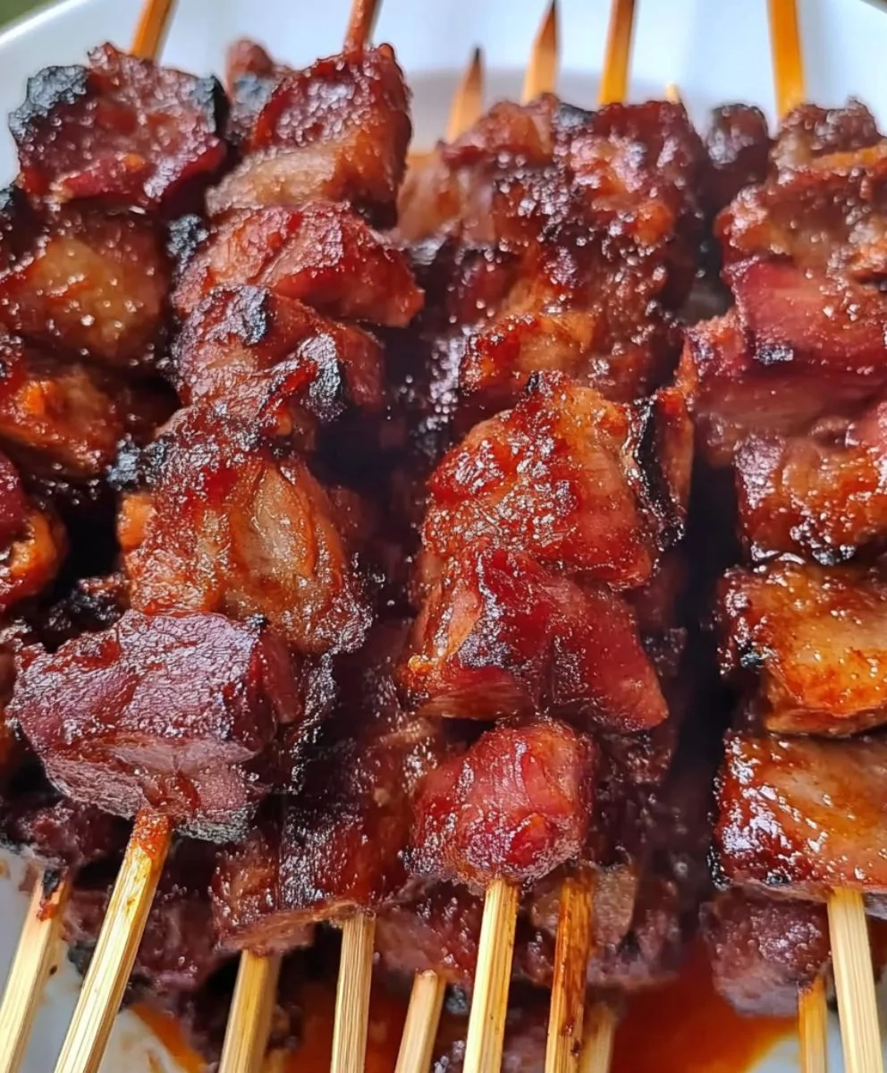 Savory grilled meat skewers with char marks and rich barbecue coating.