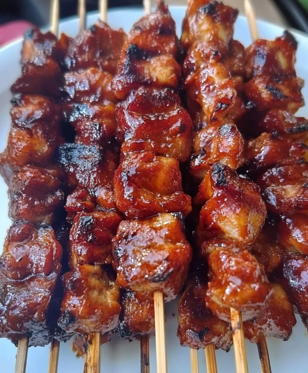Grilled barbecue skewers glistening with caramelized marinade and smoky char.