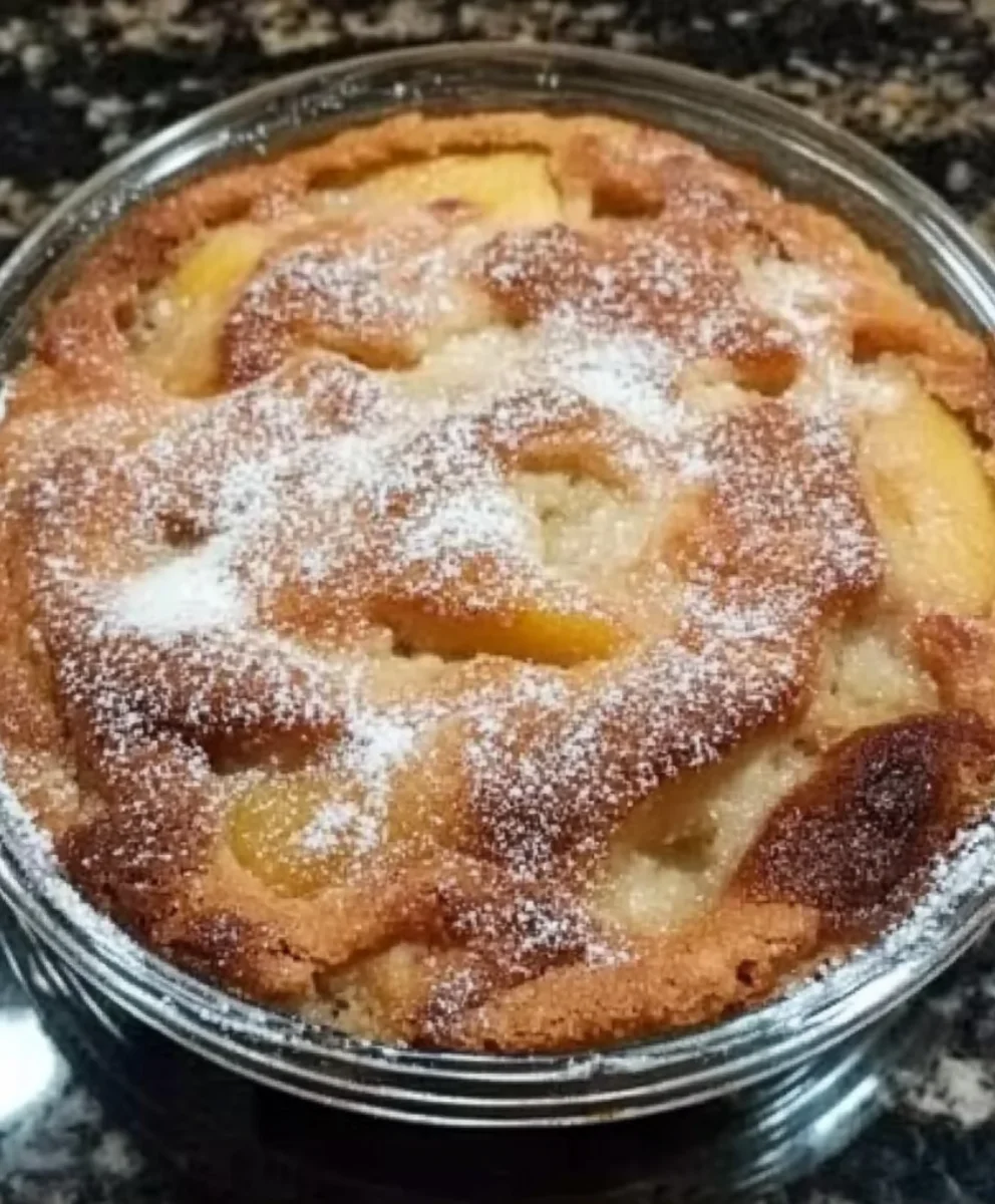 Freshly baked easy peach cobbler with golden crust and powdered sugar topping