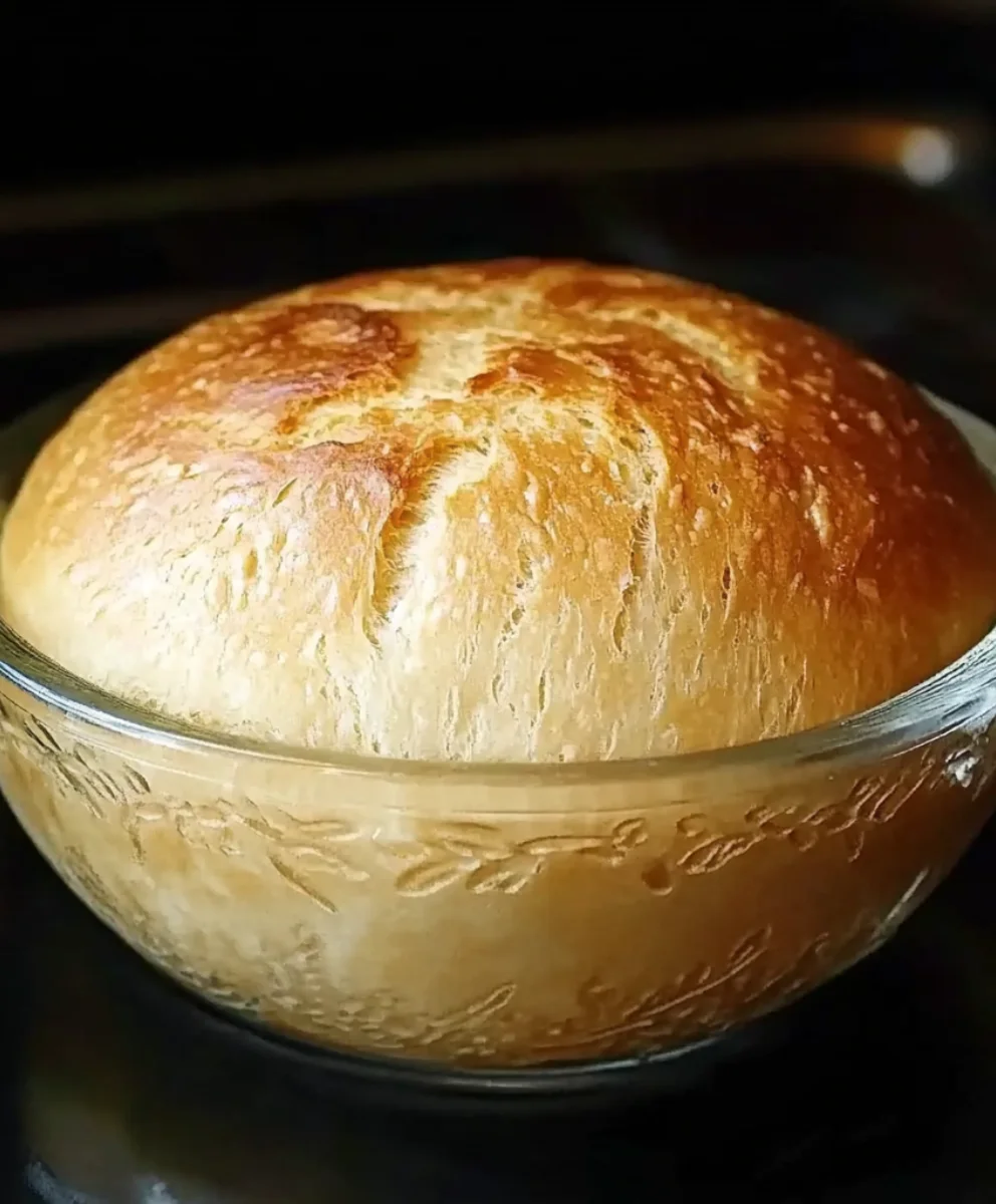 Rustic no-knead peasant bread fresh out of the oven in a glass bowl