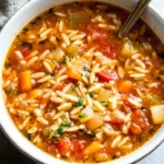 bowl of Italian sausage white bean soup with fresh spinach